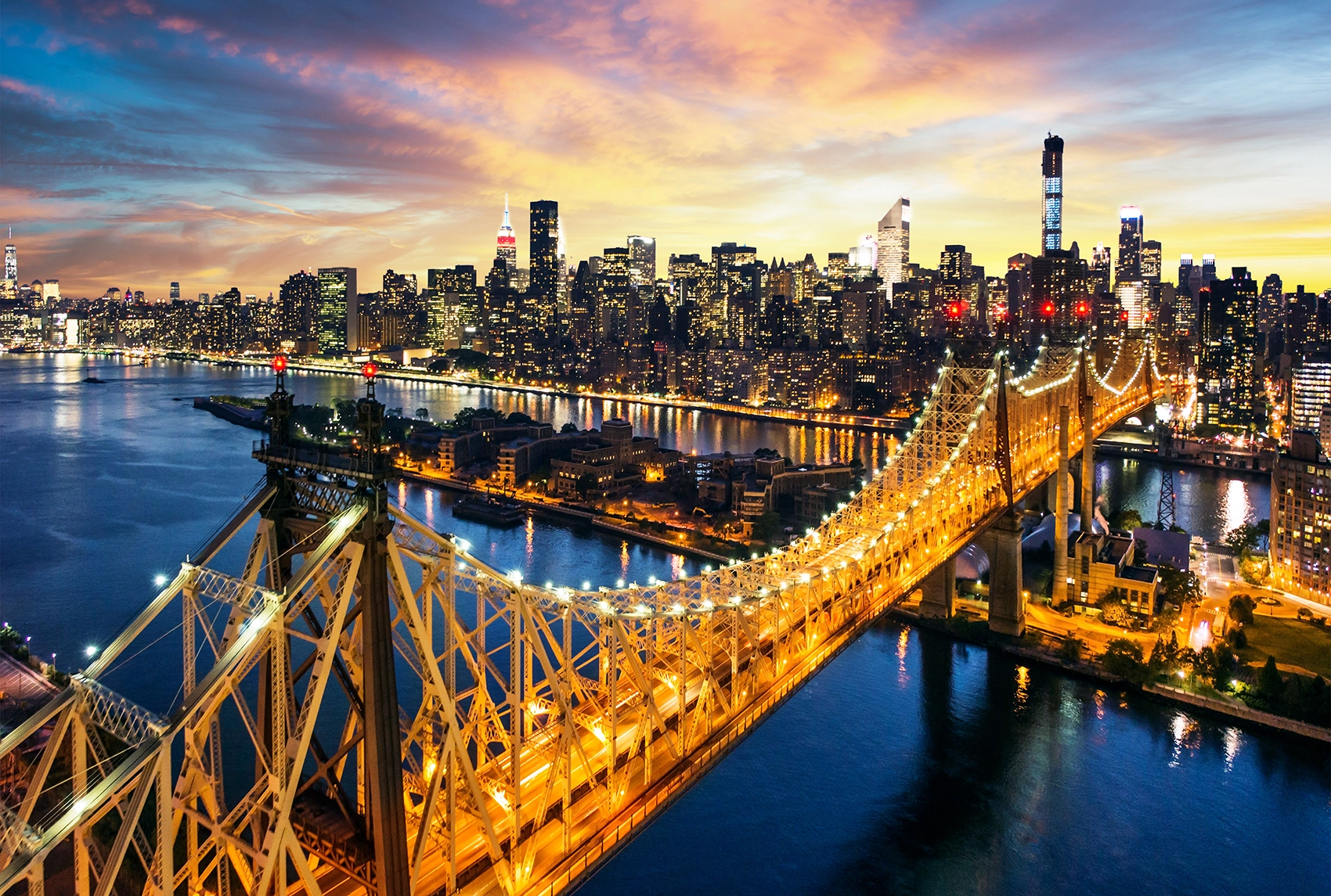 Stunning Queensboro Bridge at sunset with Manhattan skyline glowing across the East River